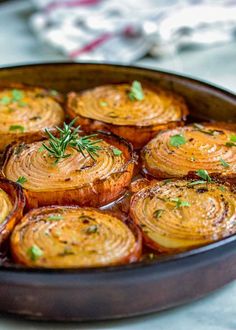 baked potatoes with herbs in a pan on a white counter top, ready to be eaten