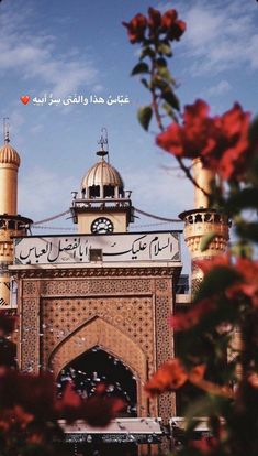 an ornate building with flowers in the foreground and a blue sky behind it,