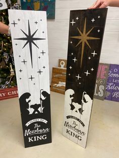 two wooden signs with the words merry christmas and nativity king written in black on them