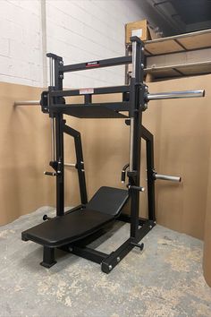 a black bench and squat machine in a room with no one on the bench or standing next to it