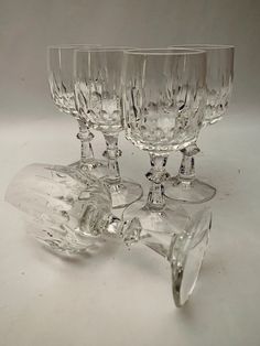 three crystal goblets sitting next to each other on a white tableclothed surface