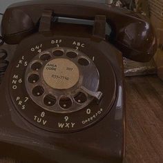 an old phone sitting on top of a wooden table