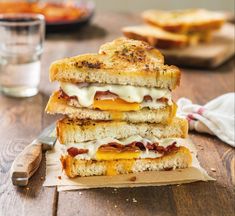 two grilled sandwiches stacked on top of each other with cheese and bacon in between