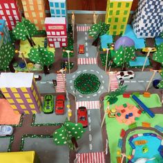 a toy city with cars and buildings on the street, roads and streets are made out of felt