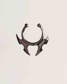 two silver colored metal rings with horns on them, against a white background that appears to be part of a pair of scissors