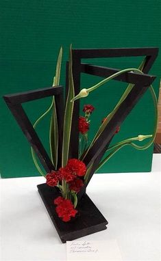 a vase filled with red flowers sitting on top of a table