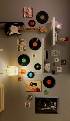 there are many different types of records on the wall in this room, including one that has an electric guitar