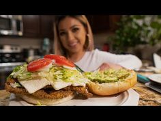 a woman sitting in front of a plate with a sandwich on it