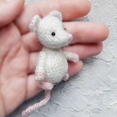 small white crocheted mouse being held by someone's hand