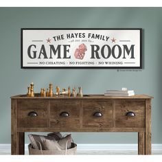 a game room sign hanging on the wall next to a wooden table with chess pieces