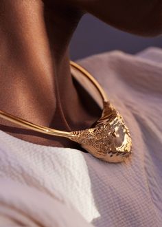 A piece featuring a bold design, forming a strong contrast between a fine line adorning the neck and a sculptural central piece, like a rugged shard of rock nestled against the skin. Gold Gilding, Bold Design, Fine Line, Wedding Necklace, Sri Lanka, Vogue, Sculpture, Chain, Skin