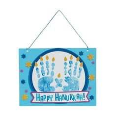 a happy hanukkah sign hanging on a wall with two handsprints