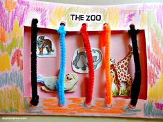 the zoo is made out of paper and some scissors are hanging from it's holder