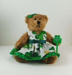 a brown teddy bear wearing a green and white dress