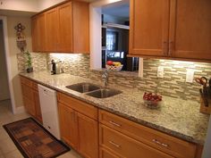 a kitchen with wooden cabinets and granite counter tops, along with a dishwasher