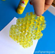 a child is making gummy bears out of construction paper with glue on the table