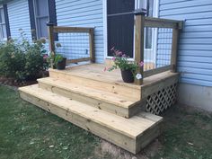 a wooden deck with planters on it in front of a house