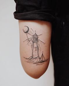 a small lighthouse tattoo on the right thigh and lower leg, with a half moon above it