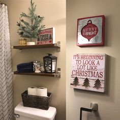 a bathroom decorated for christmas with toilet paper and towels on the shelves above the toilet