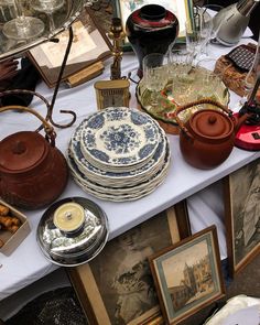 a table topped with plates and pictures next to other items on top of a white table cloth