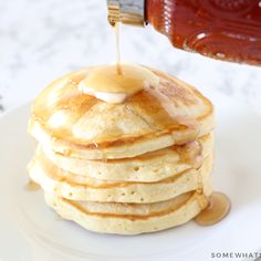 a stack of pancakes with syrup being drizzled on top