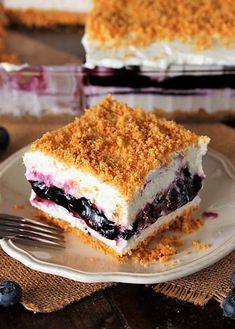 a piece of blueberry crumb cake on a plate with a fork next to it