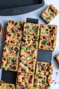 chocolate chip cookie bars cut into squares on top of a counter with sprinkles