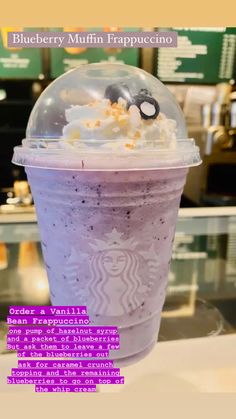 a starbucks drink with whipped cream and toppings on it in a purple plastic cup