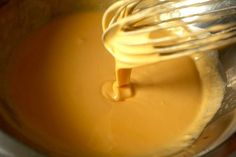 the whisk is being stirred into the liquid in the mixing bowl for the cheesecake