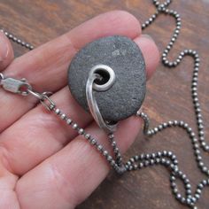 "Mens Riveted Beach Stone Necklace Silver Beach Stone Charm: This is a substantial pendant made from a natural black beach stone with a big 'ol sterling silver tube rivet and heavy silver ring. The stone has a nice soft feel and rugged texture. It hangs from a weighty sterling diamond-cut ball chain that is approximately 23.5 inches long and has a sturdy lobster-claw clasp. Pendant measures 1 1/4 inch high including ring by about 1\" wide. I had this in mind for a man, but a woman can pull this Black Natural Stones Jewelry For Beach, Minimalist Black Jewelry For Beach, Minimalist Black Jewelry For The Beach, Unique Black Beach Jewelry, Black Beach, Long Silver Necklace, Necklace Men, Necklace Chunky, Beach Stones