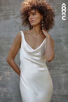 a woman with curly hair wearing a white dress