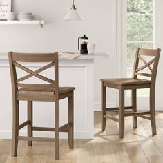 two wooden chairs sitting next to each other on top of a hard wood floored kitchen