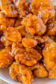 orange chicken with caramel sauce in a white bowl