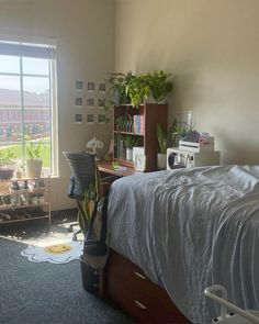 a bed room with a neatly made bed and lots of plants on the shelves next to it