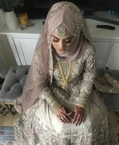 a woman sitting on top of a bed in a wedding dress