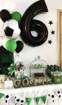 a table with balloons and decorations for a soccer themed birthday party