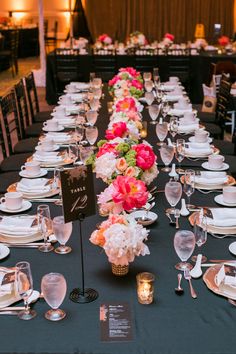 a long table is set with white and pink flowers