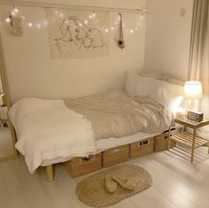 a bedroom with white walls and flooring has a bed, wicker baskets on the floor