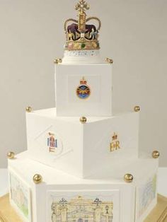 a three tiered cake with pictures on the side and a gold crown atop it