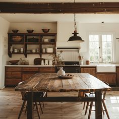 a wooden table sitting in the middle of a kitchen