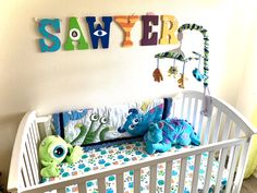 a baby crib with stuffed animals in it and the name swiffer on the wall