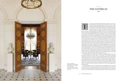 an open door leading to a dining room with chandelier and marble flooring