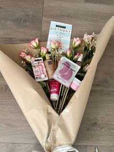 a bouquet of flowers and personal care items wrapped in brown paper