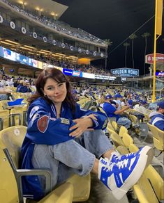 a woman sitting in the stands at a baseball game