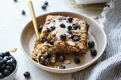 a bowl filled with granola and blueberries on top of a table