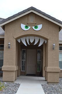 the front entrance to a house decorated for halloween with fake eyes and fangs on it