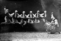 a group of men jumping in the air with their hands on each other's hipss