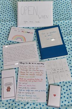 an open book with writing on it next to other papers and magnets that include pictures