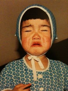 a young child wearing a blue and white dress with a bonnet on it's head