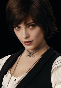 a woman with short hair wearing a black vest